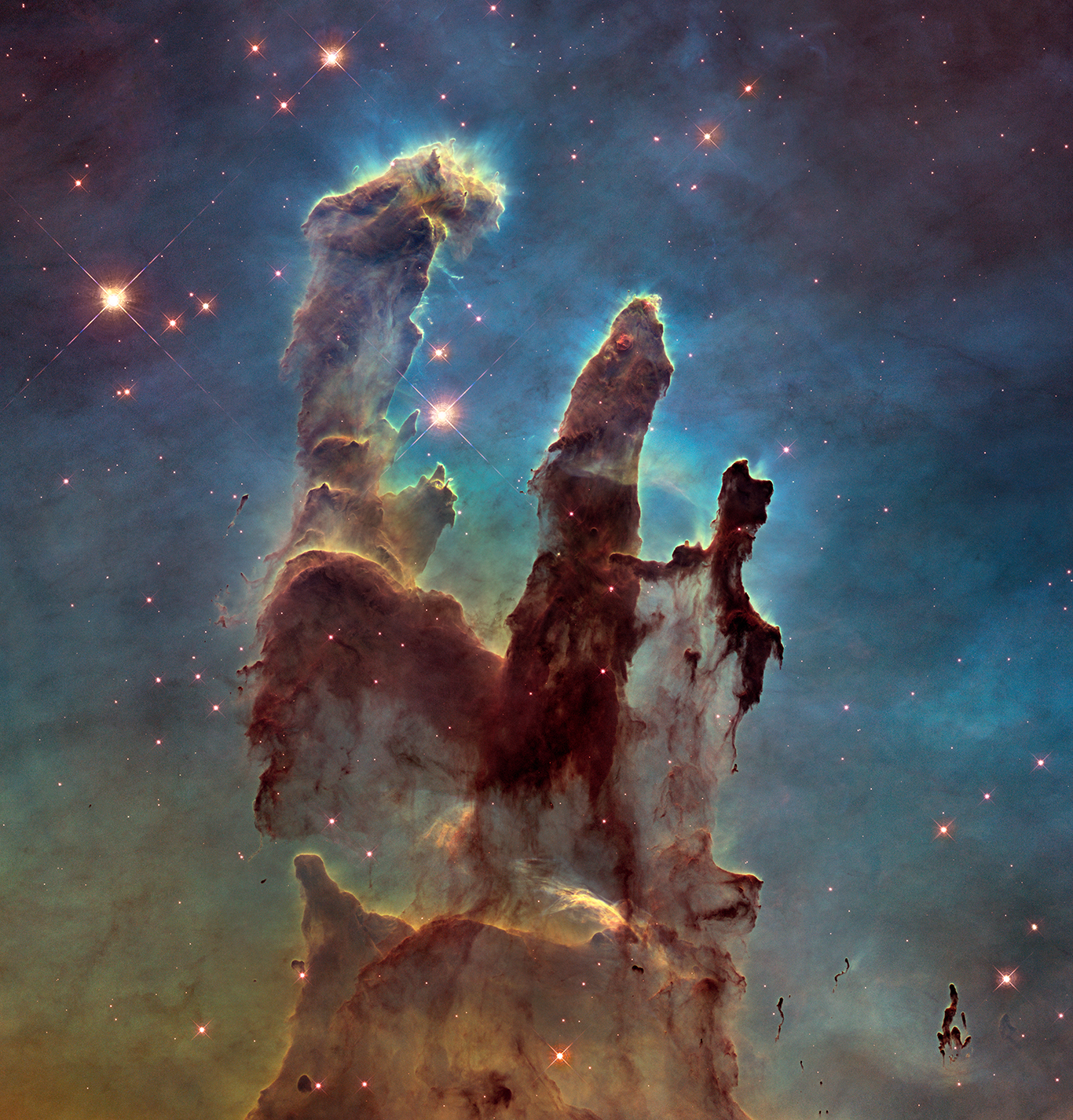 An image of the Pillars of Creation, a nebula that has three distinct pillars shooting upward.